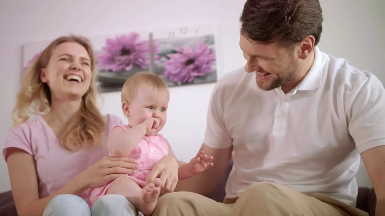 Family playing together with toy bear Mother and father with baby