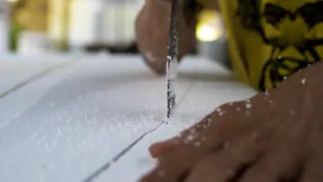 Handheld Close Up Shot of a Saw Cutting Through Polystyrene Surfboard