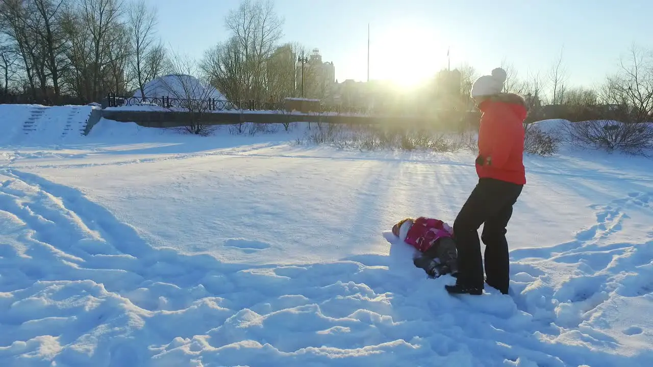 Winter family concept Mother and daughter have snow fun in slow motion