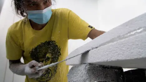 Handheld Wide Shot of Surfboard Shaper Cutting Polystyrene Board