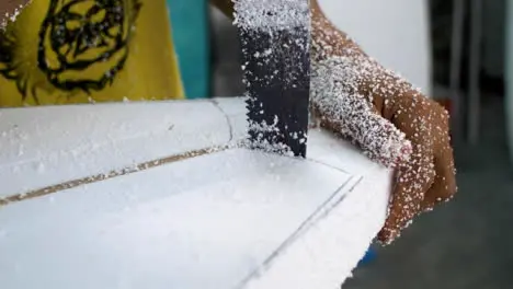 Handheld Close Up Shot of a Surfboard Shaper Cutting Polystyrene Board