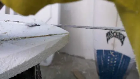 Handheld Close Up Shot of Surfboard Shaper Cutting Polystyrene Board