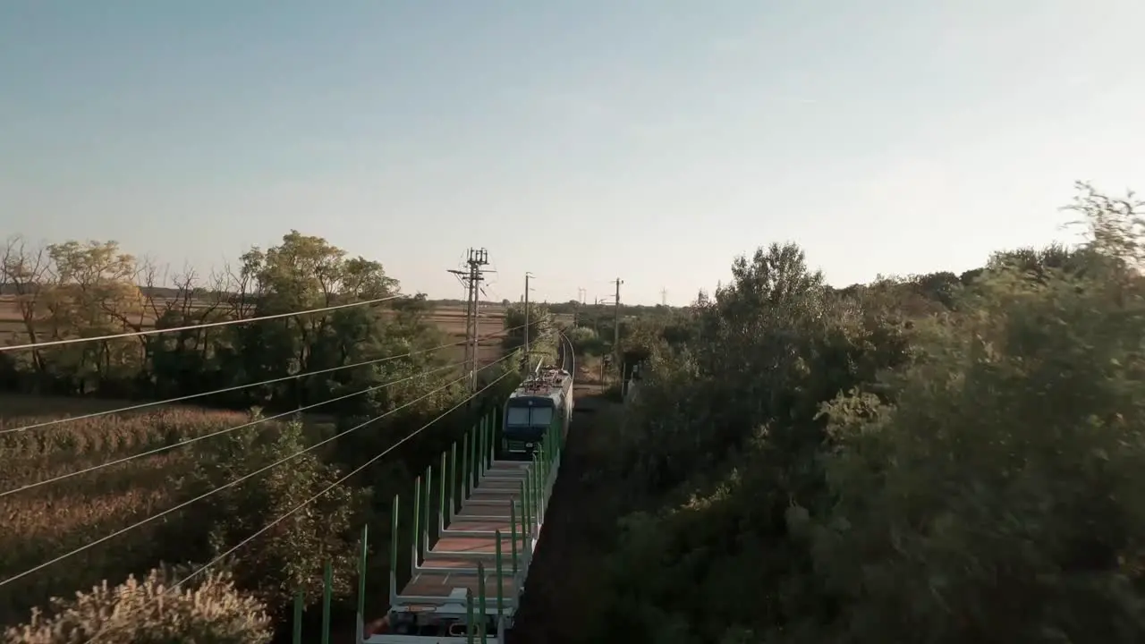 Close Encounter Aerial footage tracks an empty cargo train along expansive golden-lit cornfields