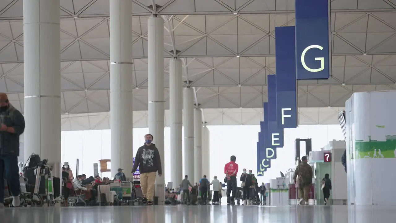 Chinese travelers and passengers walk towards the airline check-in desks located at the departure hall at Chek Lap Kok International Airport in Hong Kong