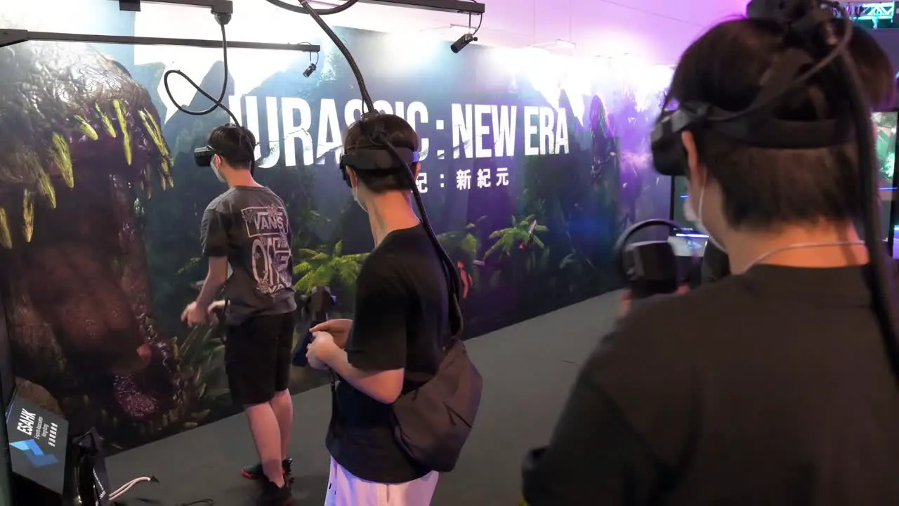 Chinese young gamers play Virtual Reality shooting videogame as they reload point and shoot at targets during the Hong Kong Computer and Communications Festival in Hong Kong