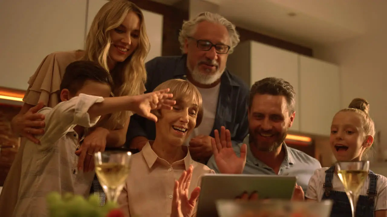 Family waving hands at camera during video call People video chatting online