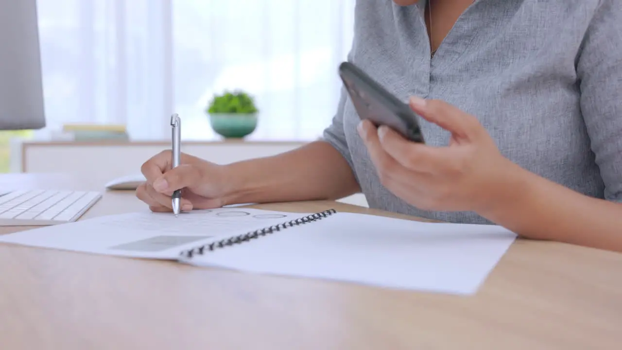 Woman writing and documents with phone