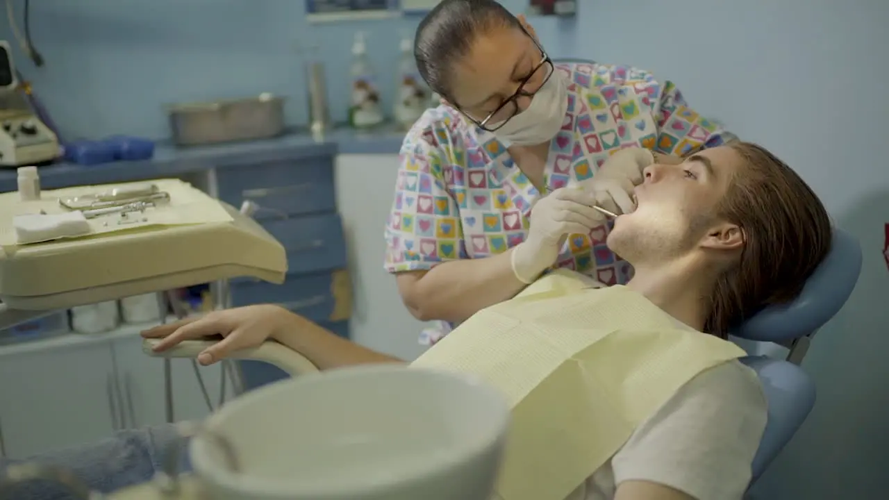 Young Man Getting His Teeth Checked By a Dentist