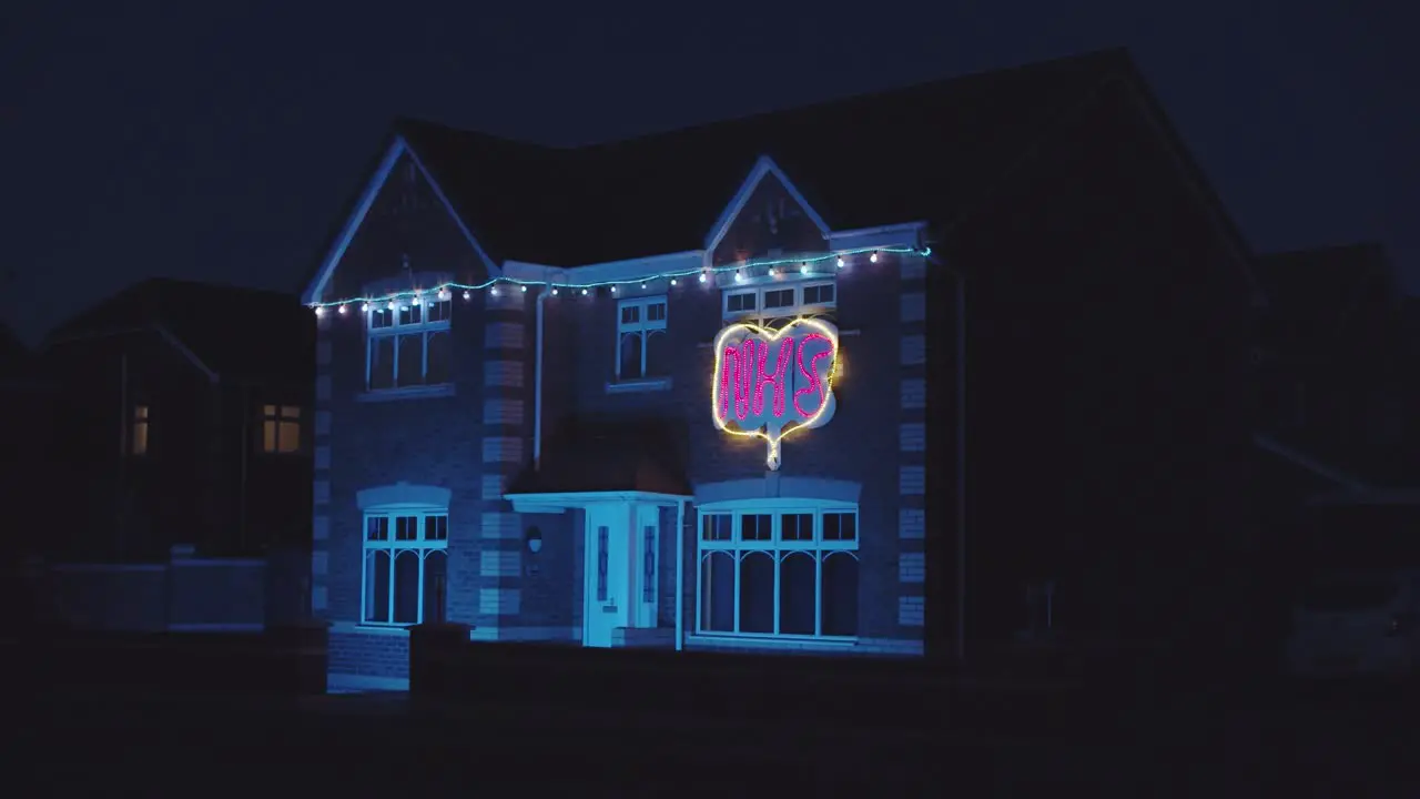 Thank you NHS house decorated with illuminated sign at night appreciating the work of the NHS UK England during lockdown