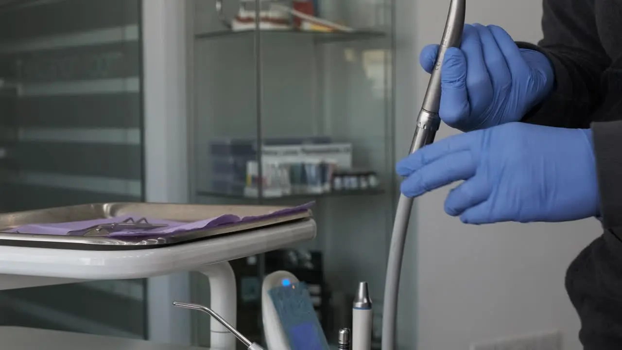 A dentist assembles a dental drill from his tray of tools