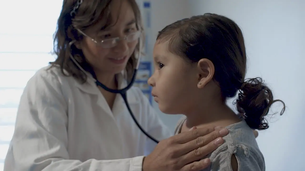 Doctor Carefully Listening to Little Girl's Heartbeat