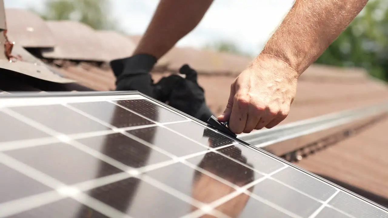 Mechanic installing solar panel to generate renewable energy close up