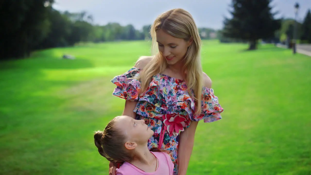 Happy family spending sunset time in garden Mother looking to daughter outdoor