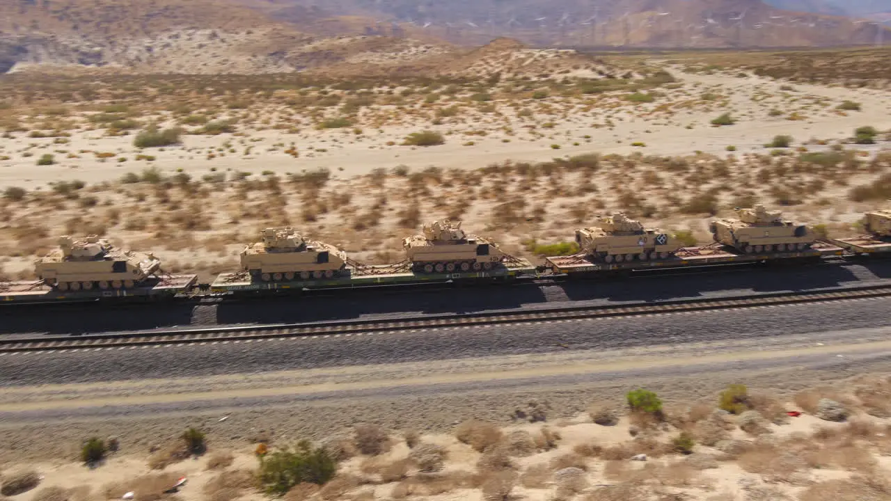 Aerial view hundreds of American Army tanks being transported through the desert by train