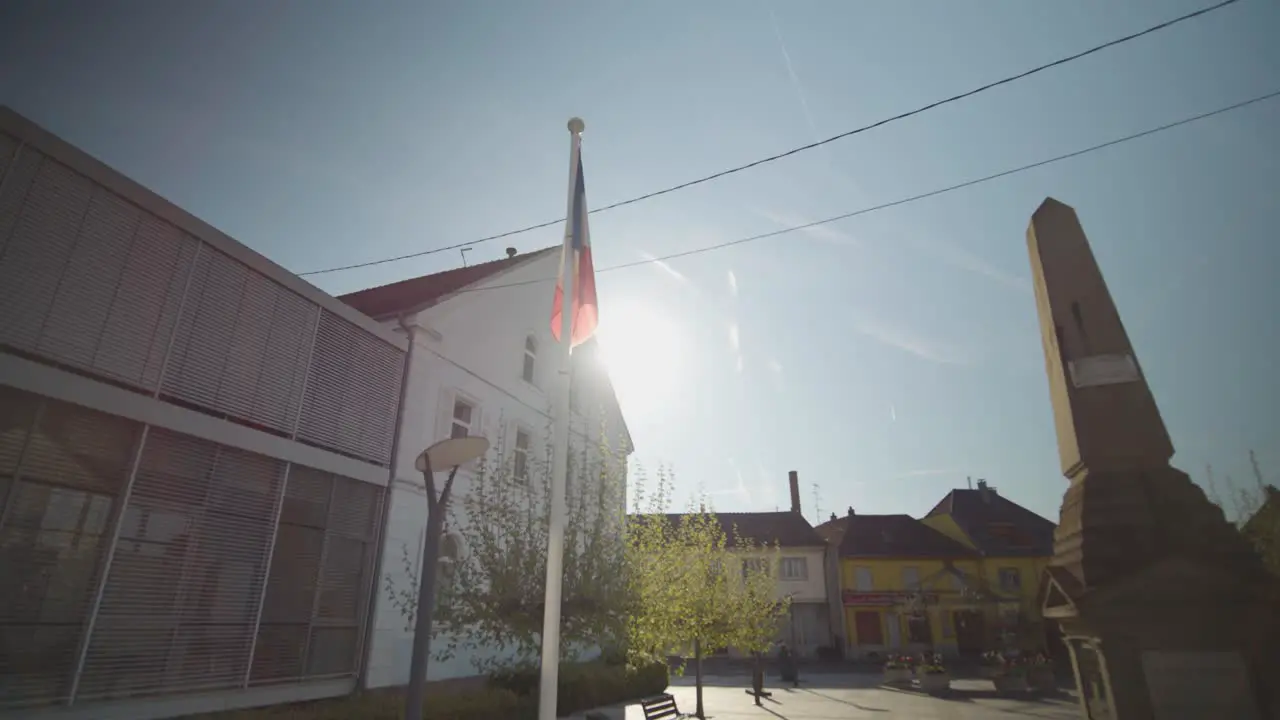 Arcing shot of a french flag beside a monument