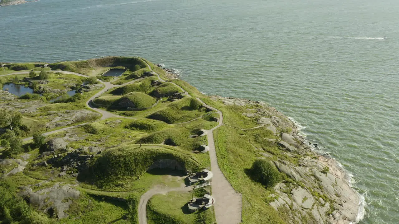 Aerial view around the cannons and the south coast of Suomenlinna fortress island on a sunny summer day in Helsinki Finland orbit drone shot