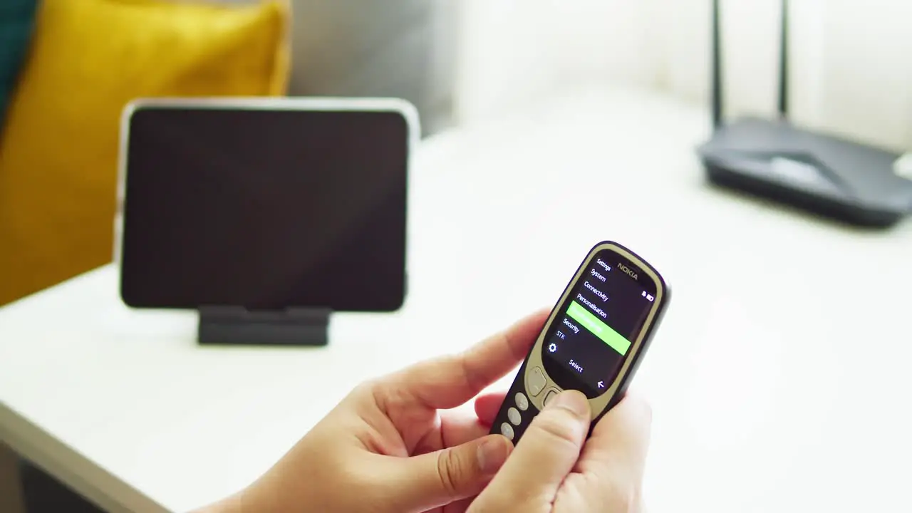 man holding old mobile NOKIA 3310 try to use and touch button and check signal to connect in the year 2022