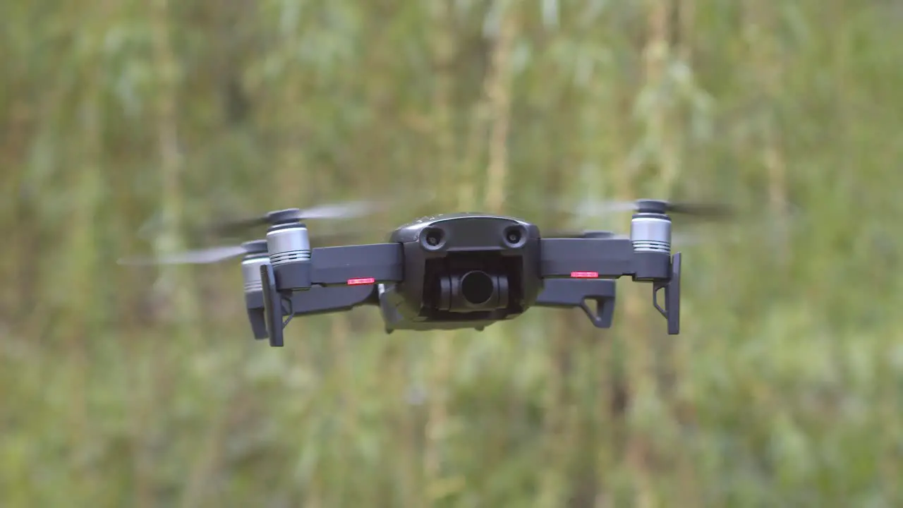 Mavic Air drone slowly flies into focus and stops to hover in place