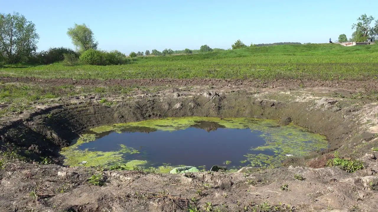 A Huge Bomb Impact Crater On The Battlefield Near Moschun During The War In Ukraine