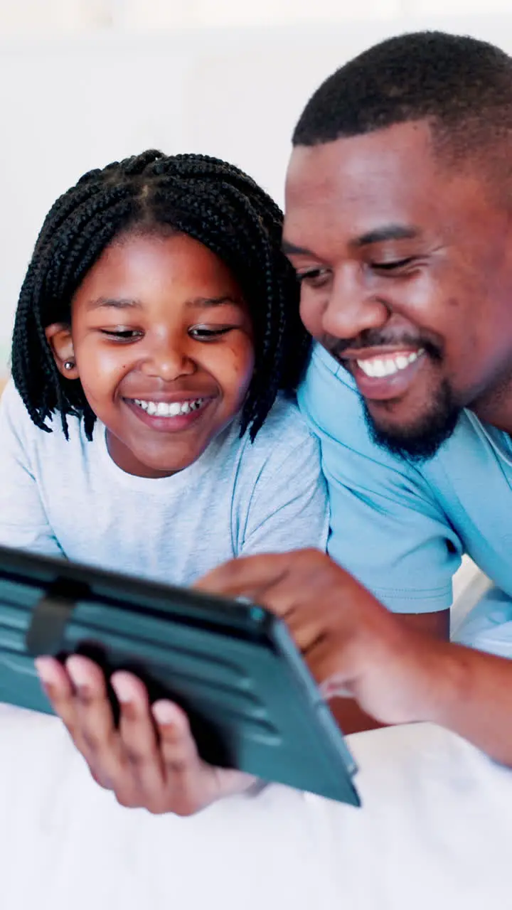 Father teaching and child with tablet in bedroom