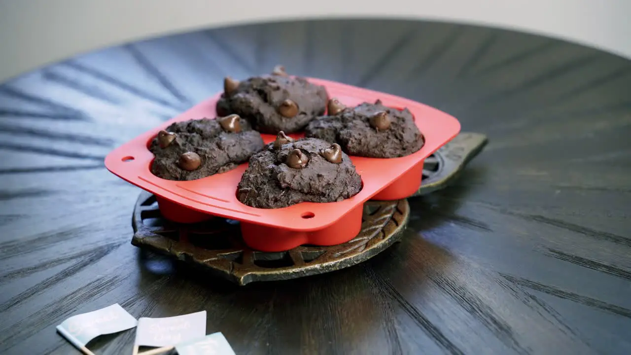 taking heart shaped beet chocolate chip muffins out of oven and placing on table to cool valentine's day