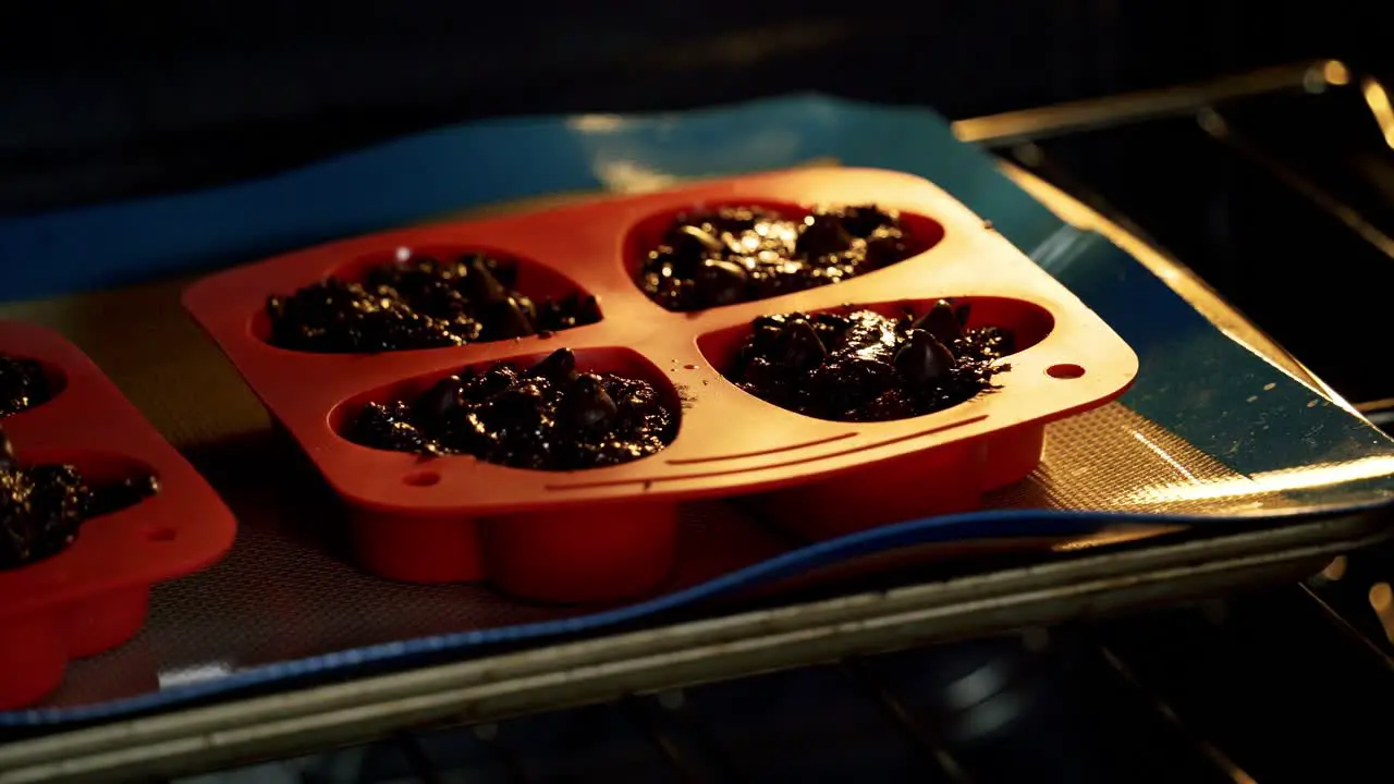 Closing oven baking chocolate chip beet muffins in red heart shaped silicone muffin pan valentine's day