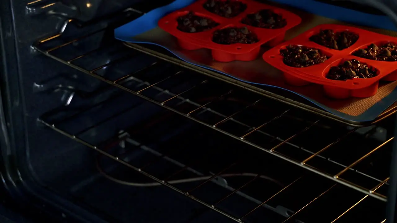 Taking chocolate chip beet muffins out of oven freshly baked valentine's day muffins in red silicone tray