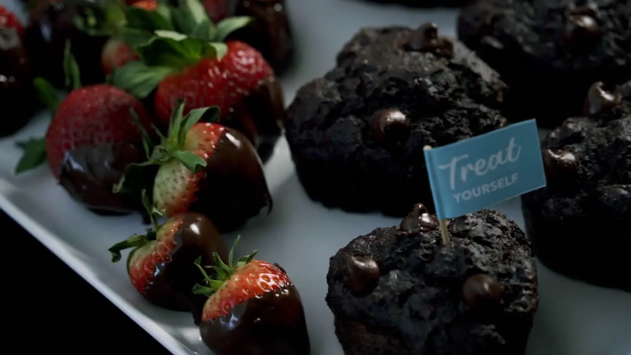 Rotating shot of chocolate beets muffins and chocolate covered strawberries for valentines day candy heart love