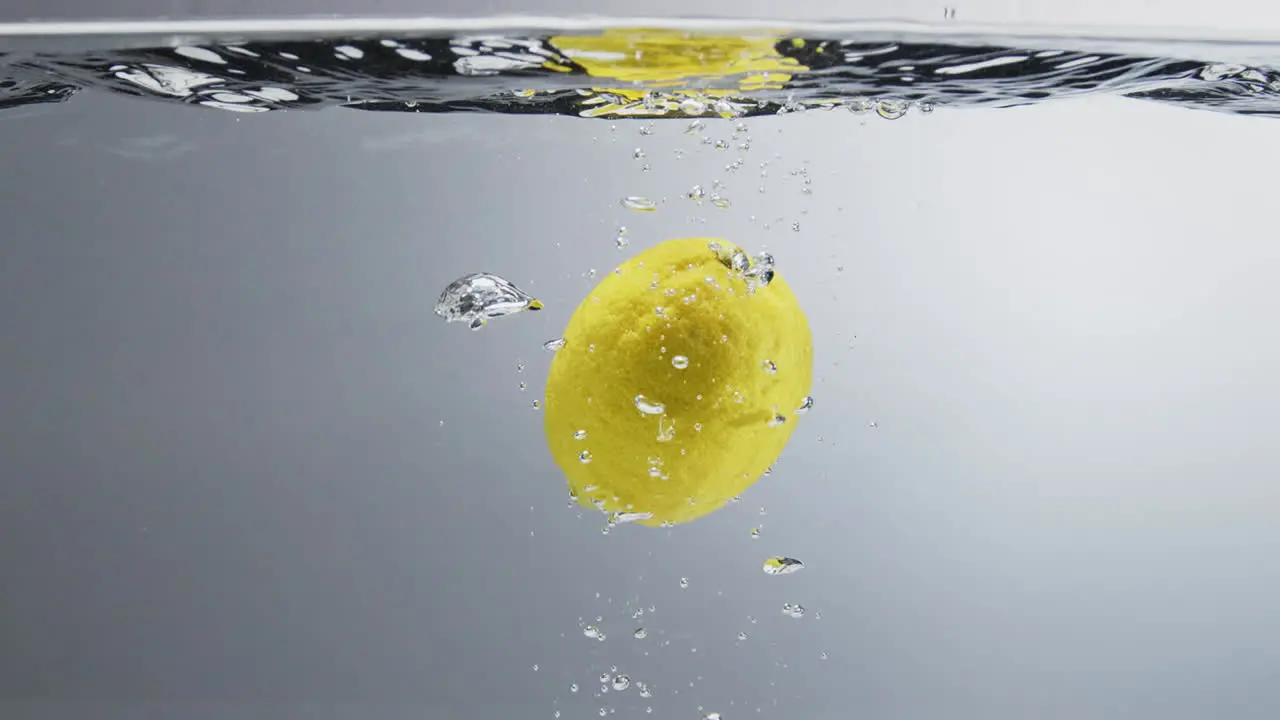 Lemon falling in water Close up slow motion