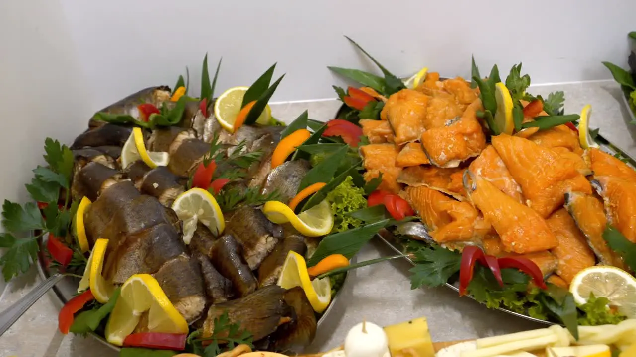 Platters with smoked fish adorned with slices of lemon and orange