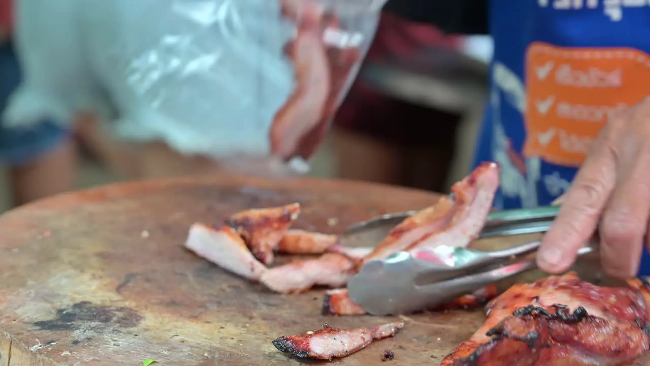 Grilled chicken and pork packed in plastic by a local vendor in a roadside restaurant in the street of Bangkok Thailand