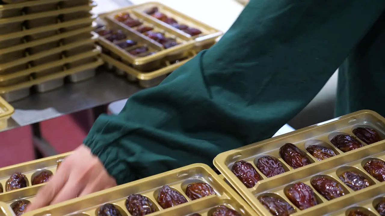 Quality assurance employee weigh fresh Medjool dates in packages before wrapping