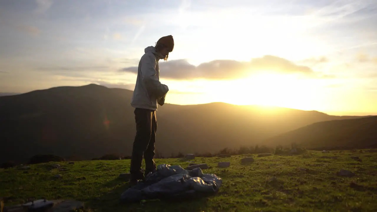 Caucasian white young man is preparing to pitch a tent after hiking