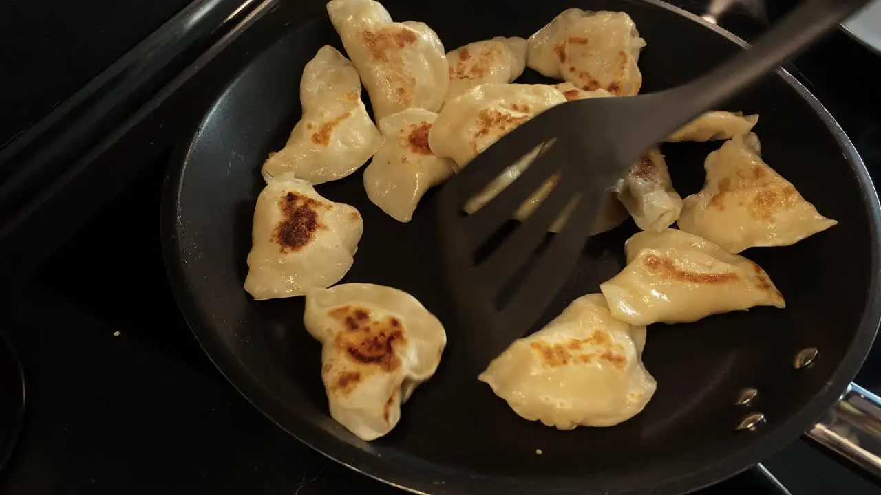 Transferring fried dumplings into the pan using a special spoon for kitchen work