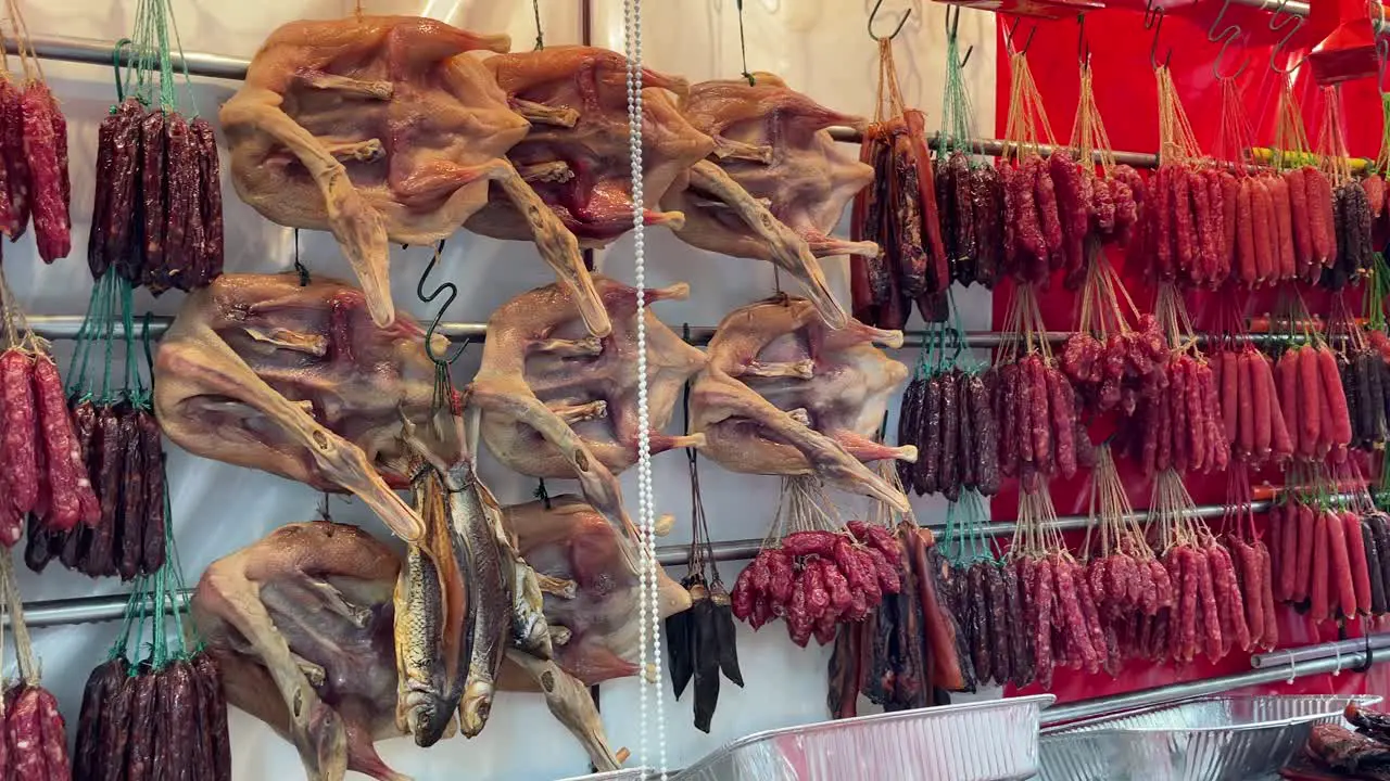 Array of Lap Cheong also known as red Chinese sausage and dried waxed duck for Chinese New Year displayed at a local market