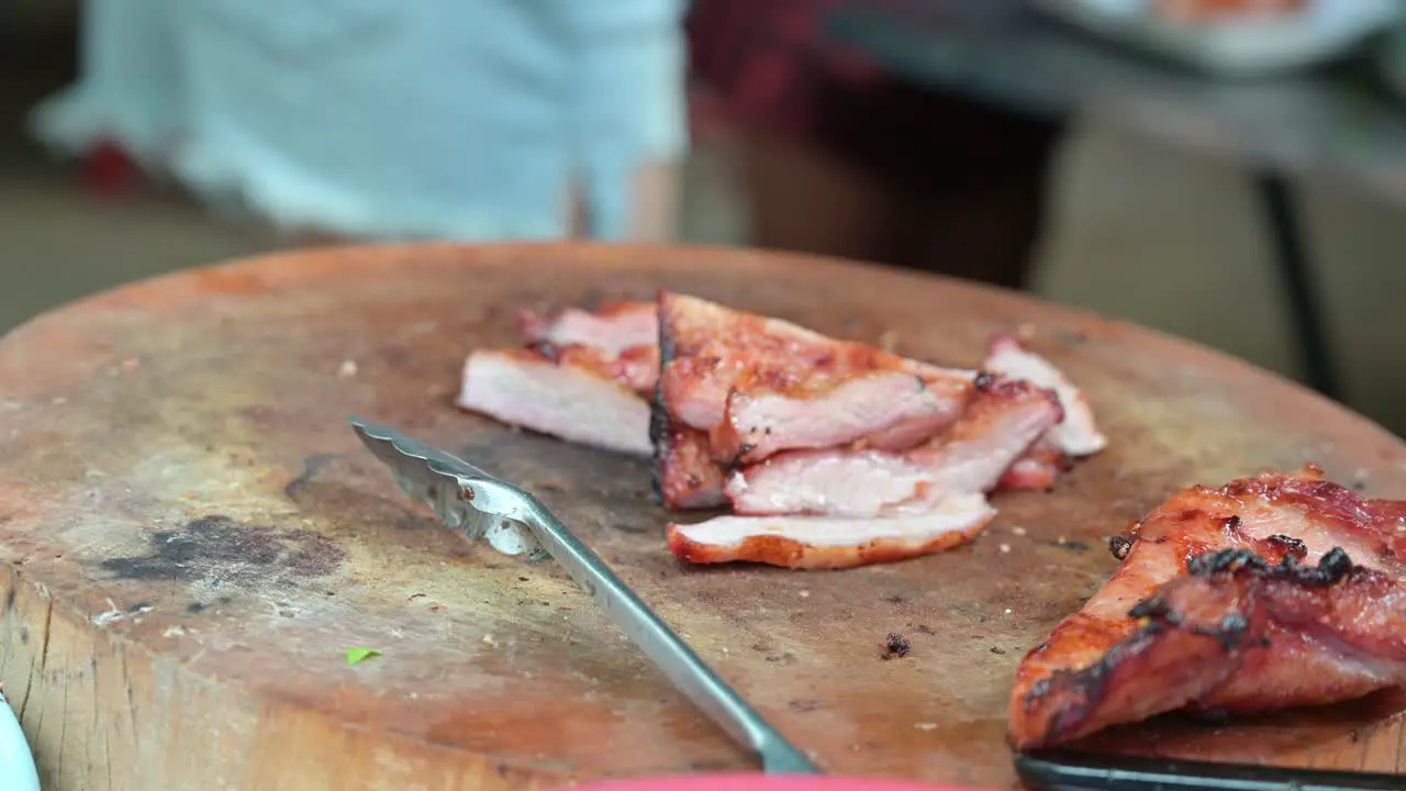 Putting in a plastic a portion of grilled pork and grilled chicken a staple food for local people that they buy from street vendors at Chatuchak Weekend Night Market in Bangkok Thailand