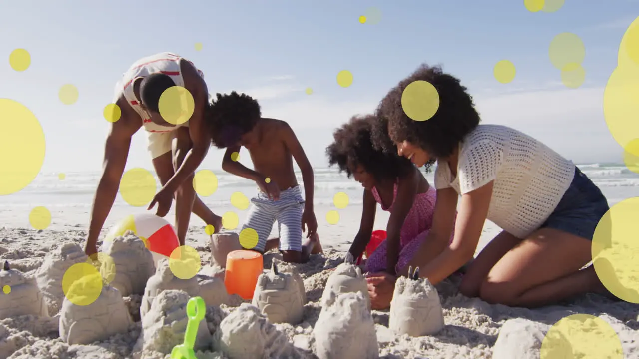 Animation of glowing spots over happy african american couple with son and daughter on beach