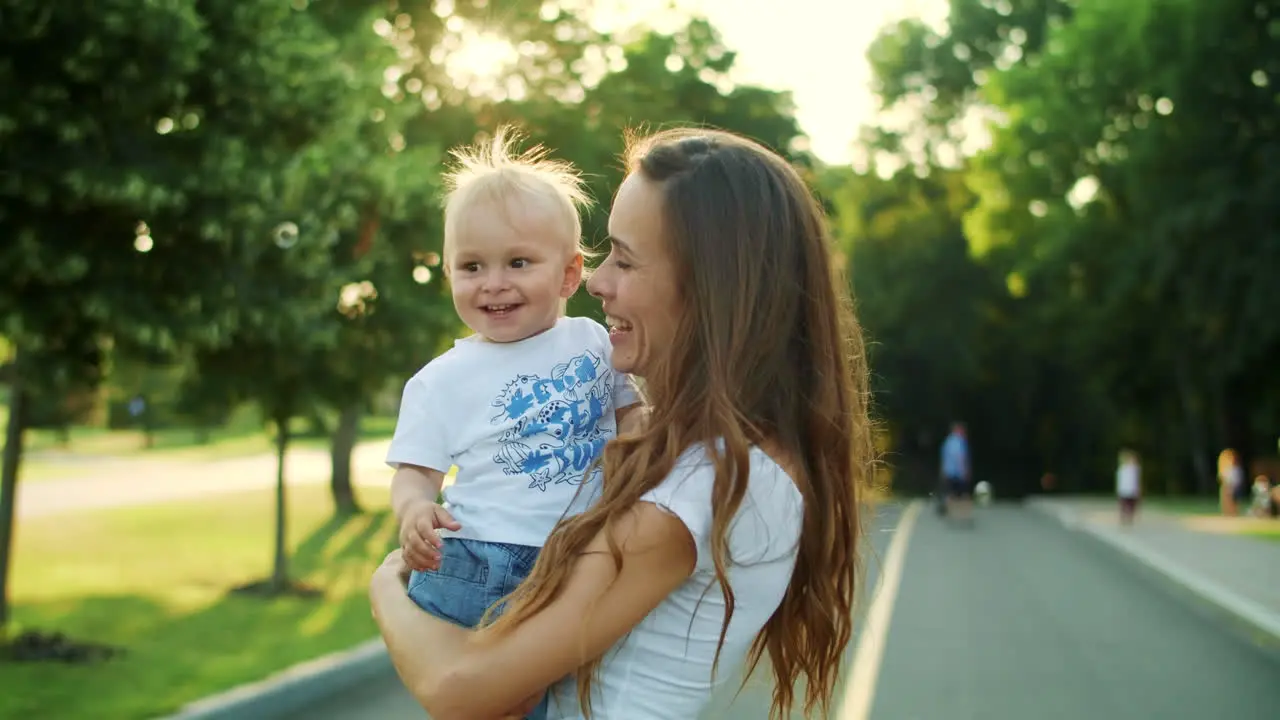 Mother and toddler looking at soap bubbles on street