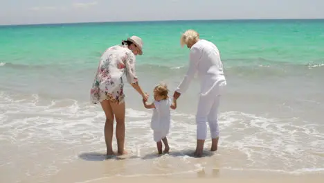 Grandma and Mom Holding Little Girl at the Beach