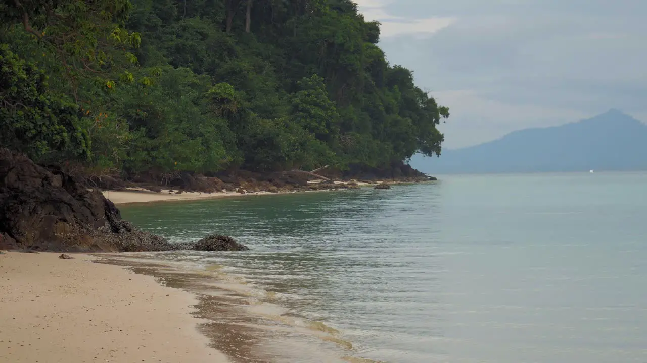 peaceful beach at tropical Island of Koh Kradan in Thailand with waves calmly crashing into the shore