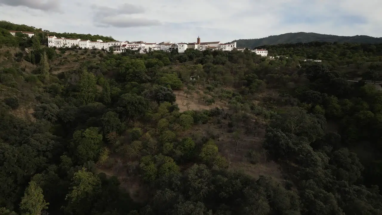 Forestry mountains and white colorful village in Spain aerial view