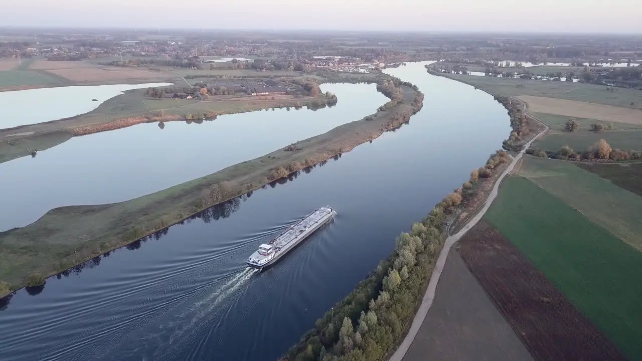 aerial of a cargo ship on a river transporting raw materials