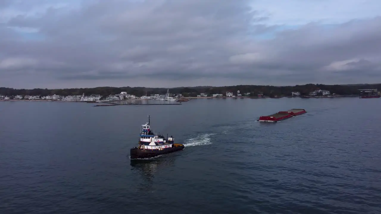 Aerial Circling tugboat pulling cargo