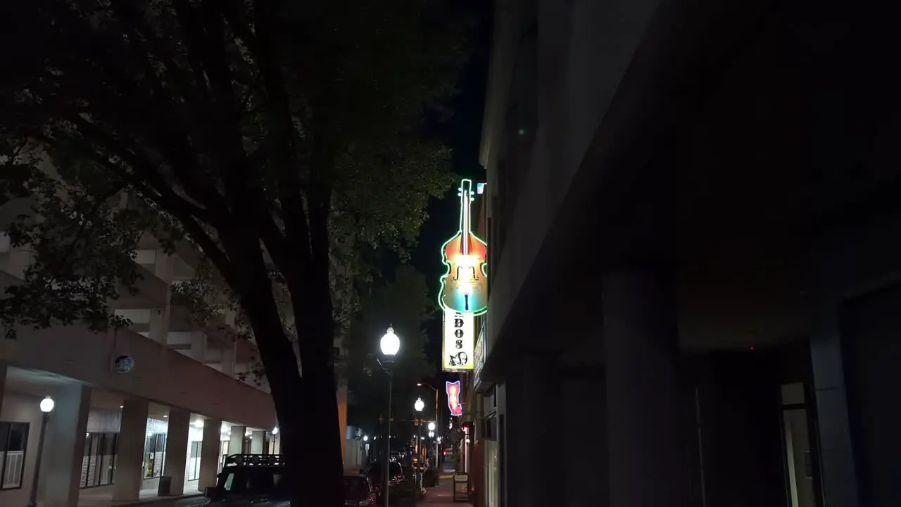 Illuminated Guitar Shaped Sign Outside Music Club In Urban Street In Virginia In The Evening