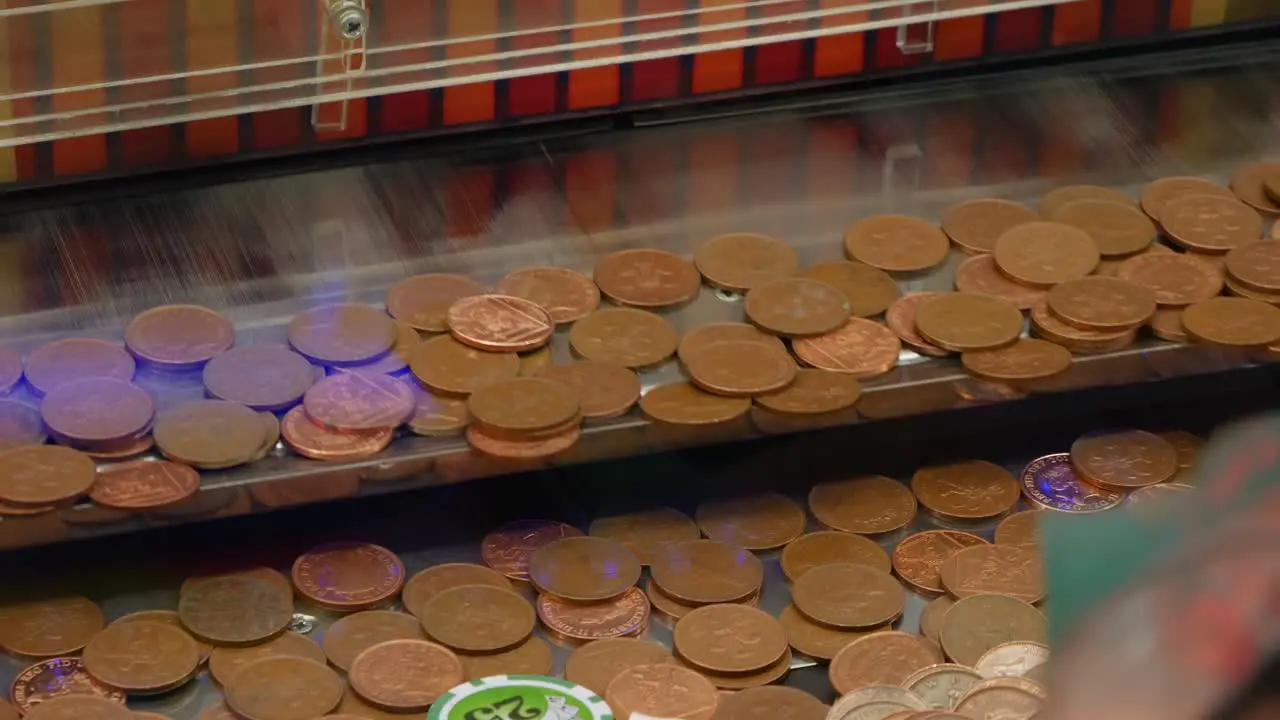 Pennies Drop Onto A Shelf Coin Penny Pusher Solt Machine In An Arcade Casino