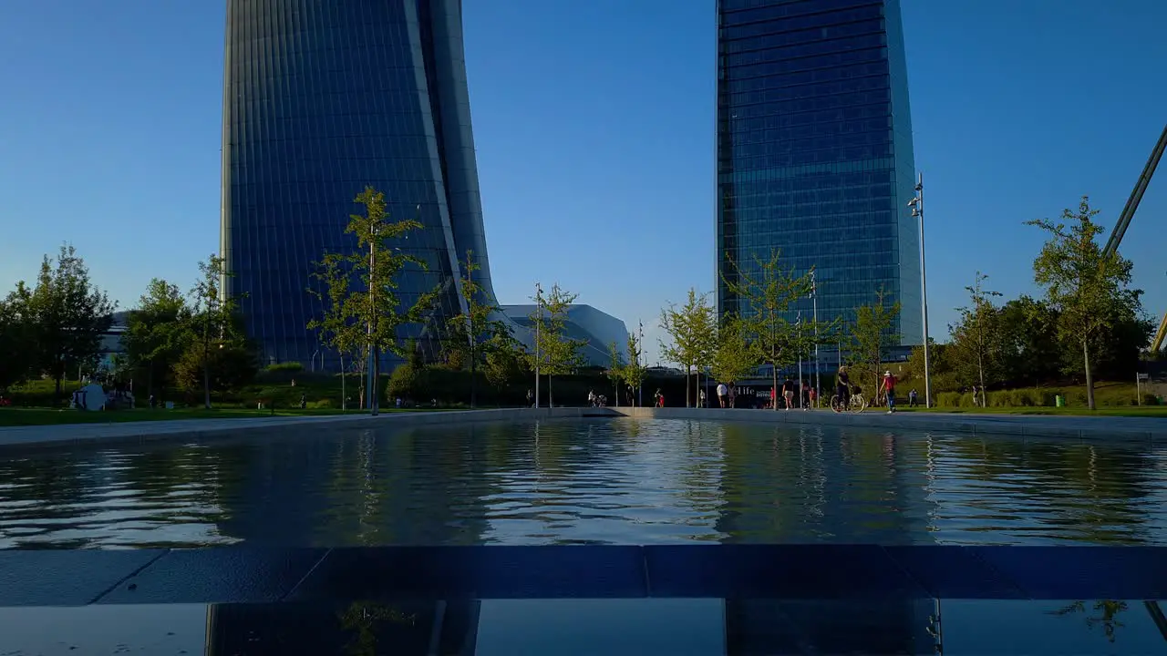 The three towers of the City Life Lombardy district in Milan Italy are reflected in the fountain below them