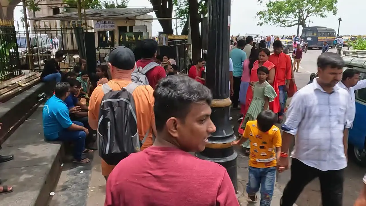 Mumbai India 20 August 2023 Tourists and locals walking along the footpath outside the Gateway of India and the Taj Palace Mumbai