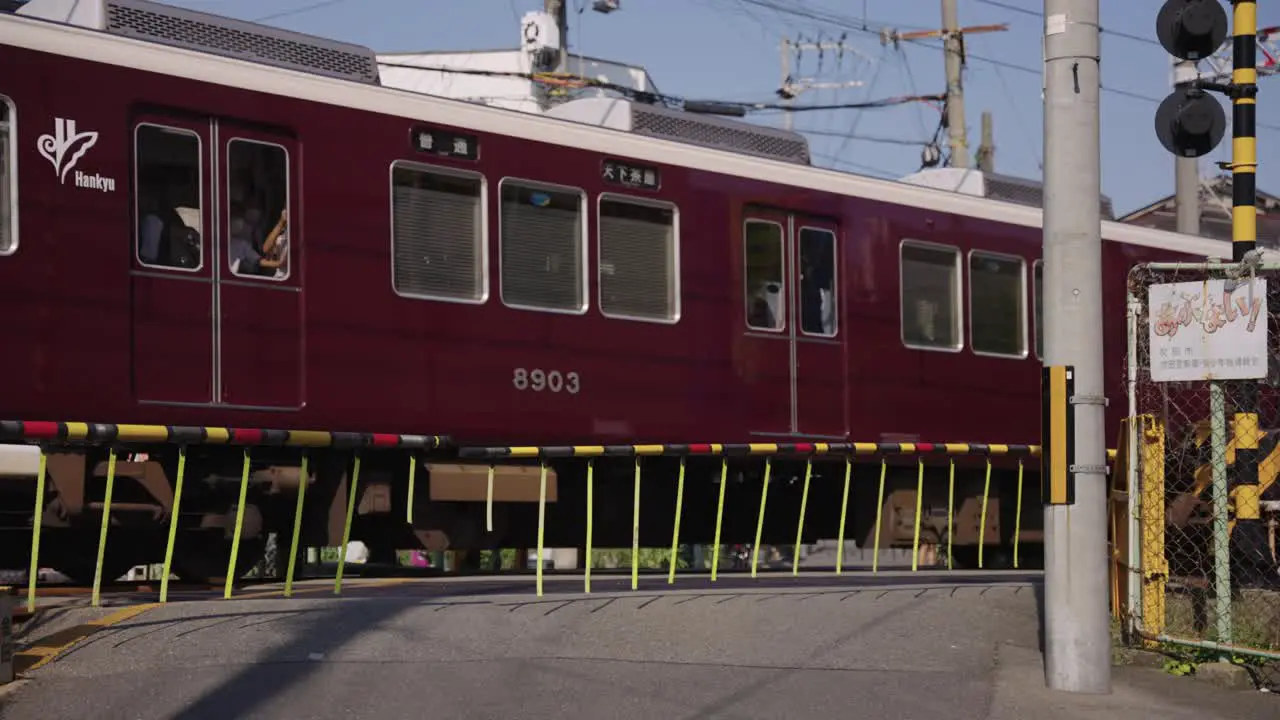 Japanese Train passing railroad crossing in the afternoon