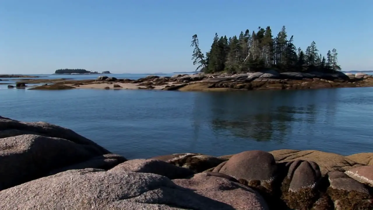 A sailboat is at anchor in a bay offshore a lobster village in Stonington Maine 1