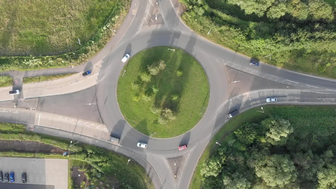 An aerial view of a roundabout in England flying upwards